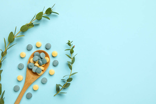 Kanál tabletták és növényi ágak kék háttér - Fotó, kép