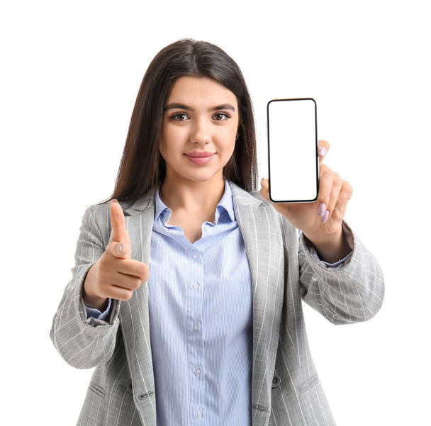 Cool young woman with smartphone pointing at viewer on white background - Valokuva, kuva