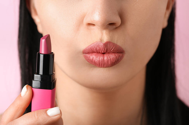 Woman with lipstick blowing kiss on pink background, closeup - Photo, Image