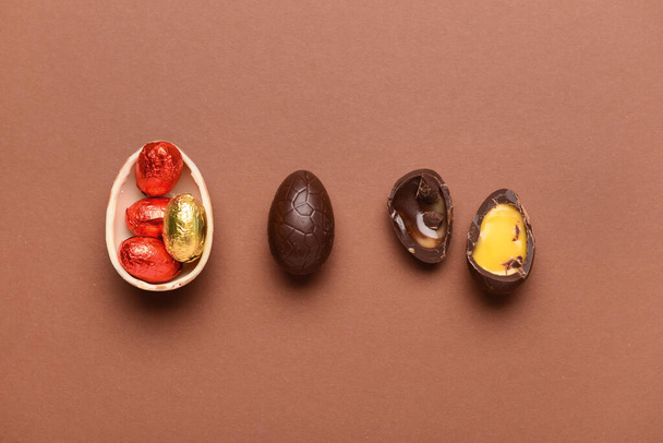 Oeufs de Pâques au chocolat et bonbons sur fond brun - Photo, image