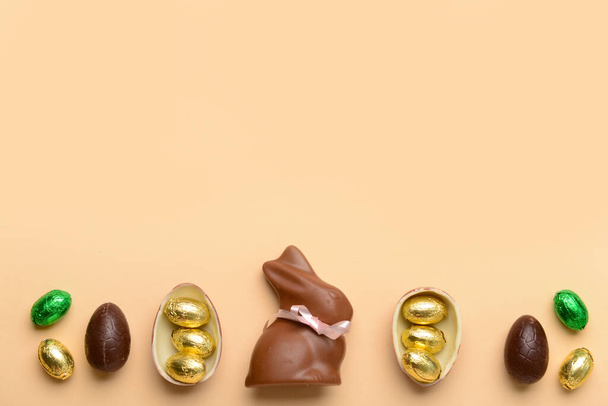 Chocolate bunny and Easter eggs on beige background - Photo, Image