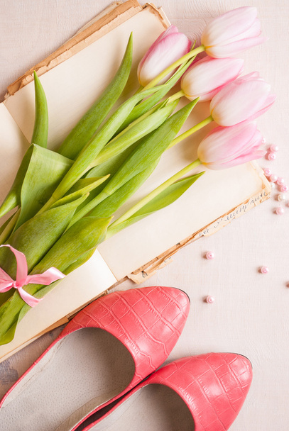 Pink tulips with womens shoes over white wooden table. Spring c - Photo, Image