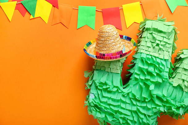 Mexican pinata with sombrero hat and flags on color background - Photo, Image