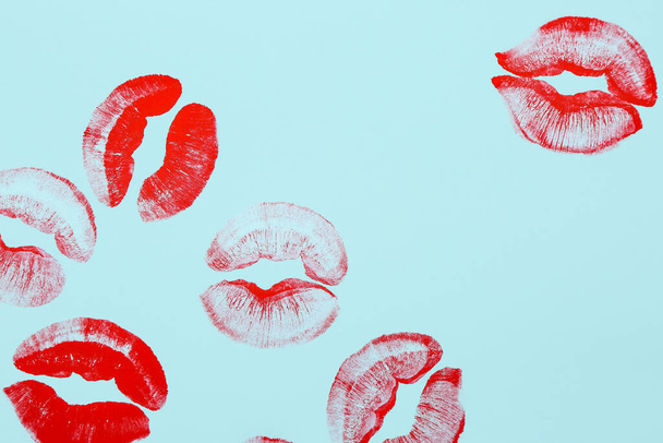 Red lipstick kiss marks on blue background - Foto, afbeelding
