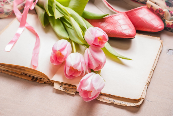 Розовые тюльпаны и чистая книга с женской обувью поверх белого дерева
 - Фото, изображение
