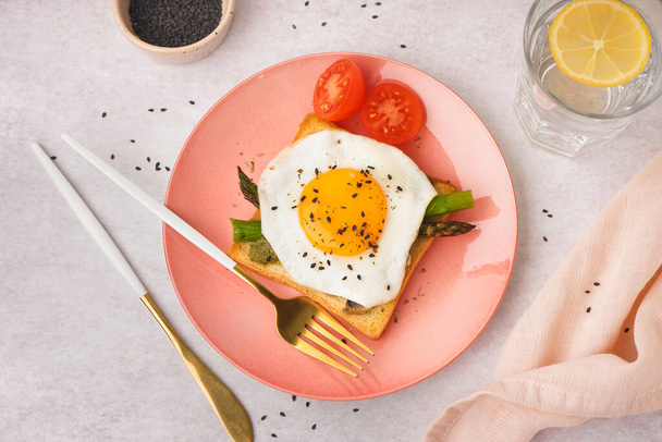 Delicious sandwich with fried egg, asparagus and tomatoes on grey background - Photo, Image