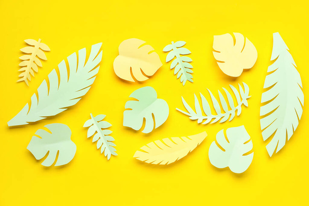 Papel hojas tropicales sobre fondo amarillo - Foto, imagen