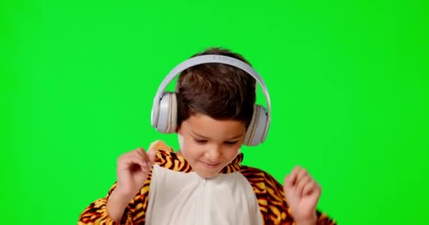 Танці, музичні навушники та дитина в костюмі на зеленому екрані в студії ізольовані на фоні. Танці, портрет обличчя та щасливий хлопчик у тигровому вбранні, що транслюється або слухає подкаст, аудіо чи радіо
 - Кадри, відео