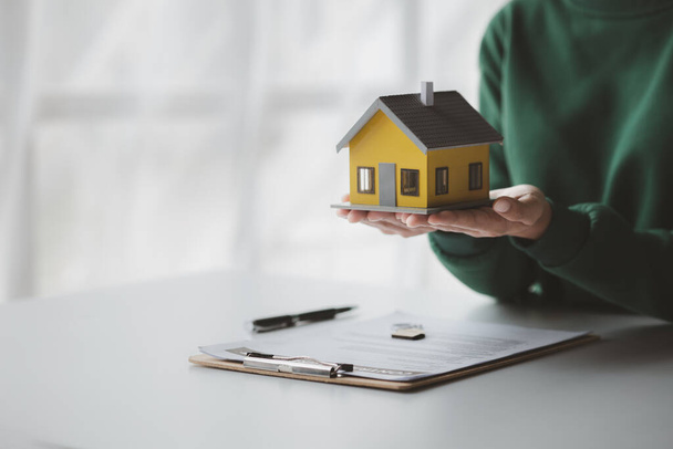 The salesperson of the housing estate in the project is preparing and verifying the contract of sale for the customer who will enter the contract. Concept of selling housing estates and real estate. - Photo, Image