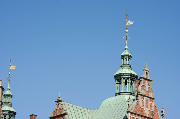 Top of the roof with spire of Rosenberg castle in Copenhagen in Denmark with a clear blue sky - Foto, imagen