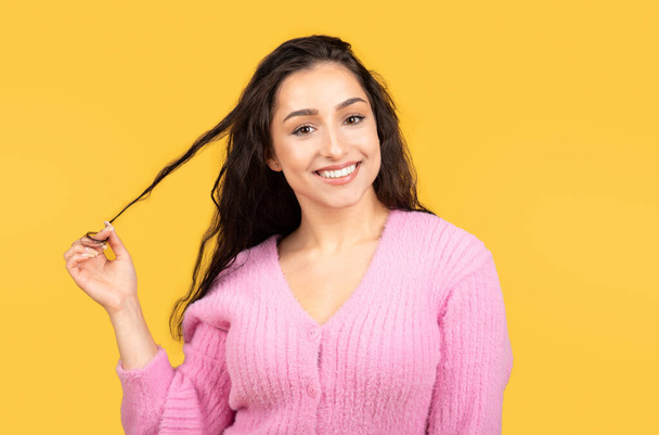 Muotokuva hymyilevä tuhatvuotinen Lähi-idän naisten turisti koskettaa hiukset, flirttailu, eristetty keltainen studio tausta, lähikuva. Elämäntapa, ihmisen tunteet, mainos ja tarjous - Valokuva, kuva