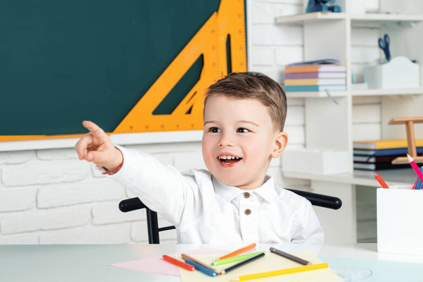 Funny little child having fun on blackboard background. School concept - Фото, изображение