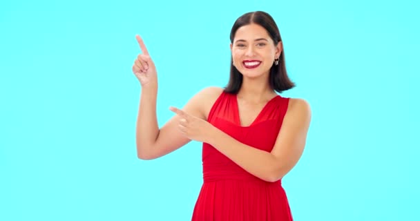 Smile, face and woman on blue background pointing to mockup, studio and color backdrop. Portrait of happy female model advertising promotion, discount sales or brand presentation of offer coming soon. - Filmati, video