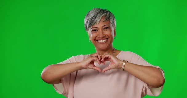 Hart, handen en senior vrouw op groen scherm met liefde, zorg en genegenheid hand gebaar in de studio. Emoji mockup, gelukkig en portret van geïsoleerde vrouw met teken voor dank, steun en liefdadigheid. - Video
