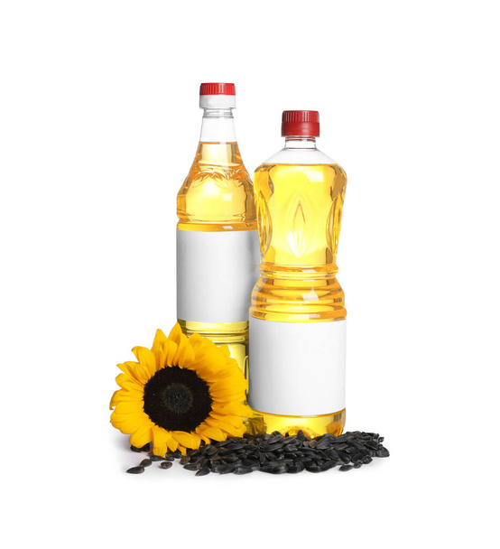 Bottles of sunflower cooking oil, seeds and yellow flower on white background - Foto, immagini