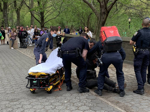 Młody bezdomny zaatakował kobietę w Central Parku. 16 kwietnia 2023, Nowy Jork, USA: Młody bezdomny, który leżał na betonowym siedzeniu na 5th Avenue z 67 ulicy nagle wstał i zaatakował młodą damę bijącą ją  - Zdjęcie, obraz