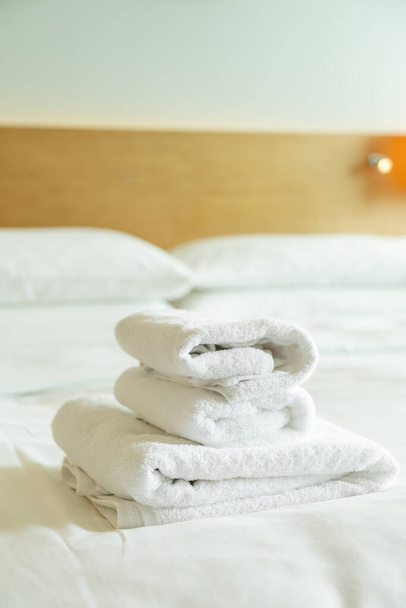 close-up white towel stack on bed - Фото, изображение