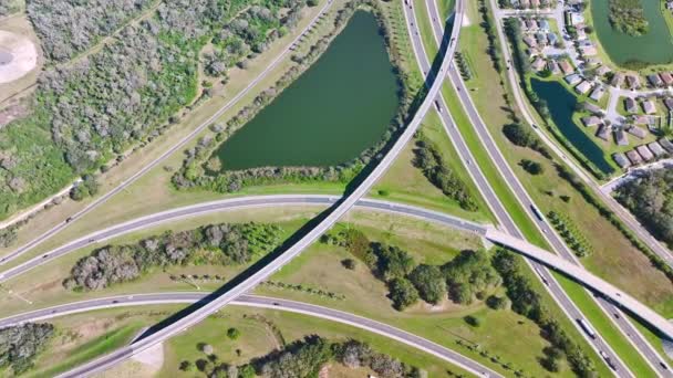 Elevated view of freeway exit junction over road lanes with fast moving traffic cars and trucks. Interstate transportation infrastructure in USA. - Video, Çekim