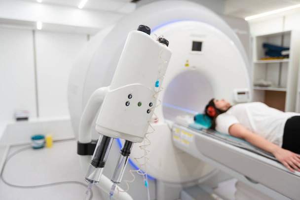 Orvosi CT vagy MRI vizsgálat egy beteggel a modern kórházi laboratóriumban. A radiológiai osztály belügyminisztere. Technológiailag fejlett felszerelés a fehér szobában. Mágneses rezonanciás diagnosztikai gép. - Fotó, kép