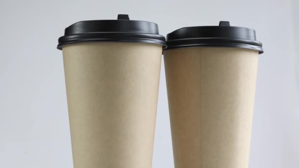 Umweltfreundliche Einweg-Kaffeetassen aus braunem Papier auf weißem Hintergrund. Tassen zum Mitnehmen Recycling und Öko-Konzept, Looped 4K Stop-Motion-Animation aus nächster Nähe - Filmmaterial, Video