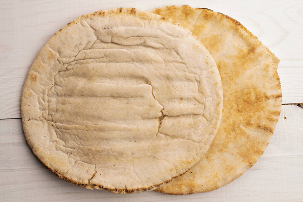 Freshly baked aromatic pita, close-up, on a wooden table, top view. - Foto, Imagen
