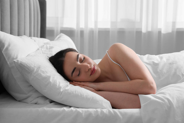 Beautiful young woman sleeping in soft bed at home - Foto, afbeelding