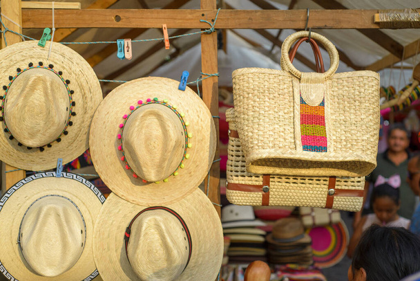 Tassen en hoeden gemaakt met geweven palmvezels op een Mexicaanse straat ambachtelijke markt. - Foto, afbeelding