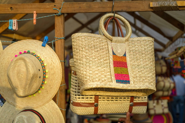 Tassen en hoeden gemaakt met geweven palmvezels op een Mexicaanse straat ambachtelijke markt. - Foto, afbeelding