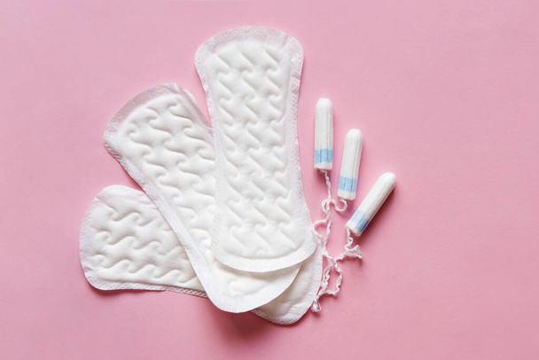 Feminine sanitary pads pattern and tampons on pink background. Hygiene care during critical days, caring for women's health. Daily and monthly protection. copyspace. menstrual cycle. - 写真・画像