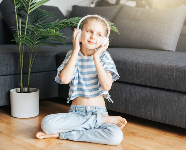 Cute little girl listening to music in headphones  at home. - Photo, Image