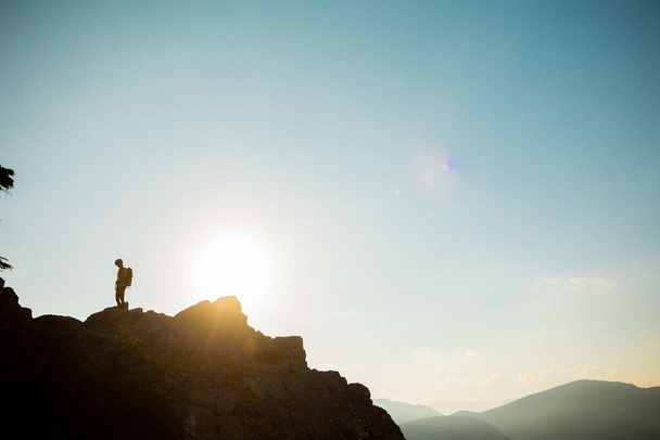 Silhouette of a girl with a backpack walking along a mountain range. climber on top of the mountain. The concept of sports and active life. travel in the mountains. - Photo, Image