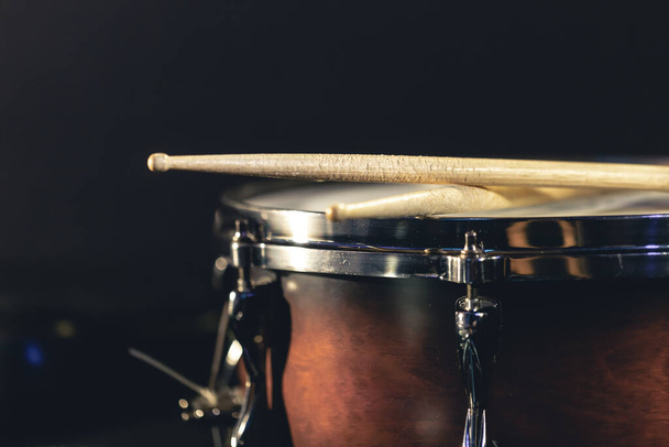Close-up, snare drum and drumsticks on a dark background, concert concept, percussion instrument close-up. - Fotó, kép