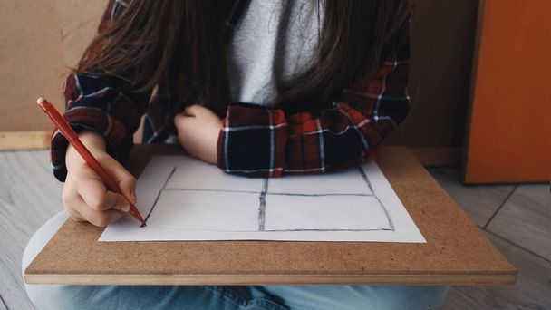 Children creativity. Painting girl. Inspiration art. Female kid drawing window shape sitting on floor in light studio interior. - Photo, Image