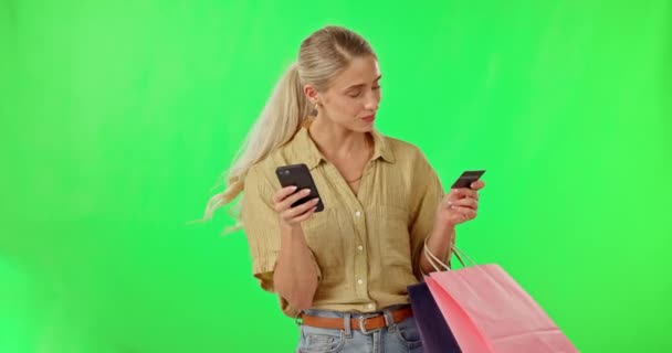 Mujer feliz, teléfono y bolsas de compras en pantalla verde con tarjeta de crédito contra fondo de estudio. Retrato de mujer en smartphone con bolsa de regalo para la compra, compras en línea o comercio electrónico en maqueta. - Metraje, vídeo