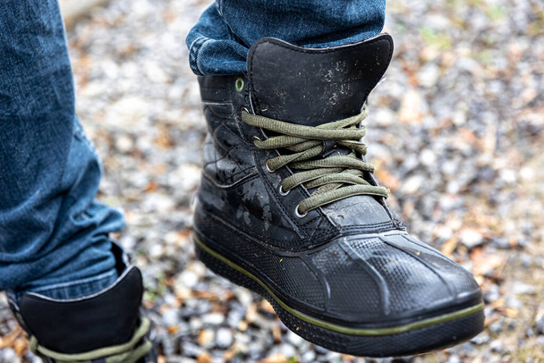 Une paire de bottes pour hommes durables, un homme en chaussures de qualité se tient sur du gravier. - Photo, image