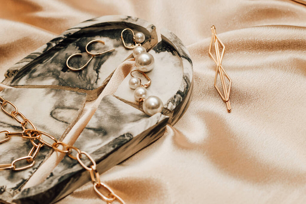 Bijoux femme, chaîne dorée, bijoux tendance sur fond de soie. - Photo, image