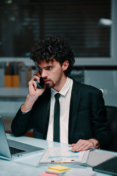 Serious young businessman answering phone call from business partner - Photo, Image