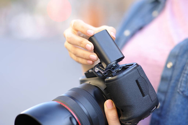 Close up portrait of a photographer changing battery on camera - Φωτογραφία, εικόνα