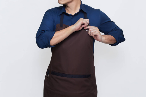 Asian Man wearing Apron in casual stylish clothing, standing tall pose with both hands both hands tightening the apron strings , ready to work, no face isolated white background - 写真・画像