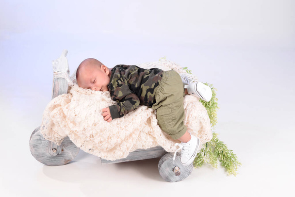Bebek kıyafetleri içinde bebek yumuşak örgü, mutlu çocuk, çocuk koruma konsepti üzerinde gülümsemeyle tatlı uyur. Hediye tebrik kartı projesi. - Fotoğraf, Görsel