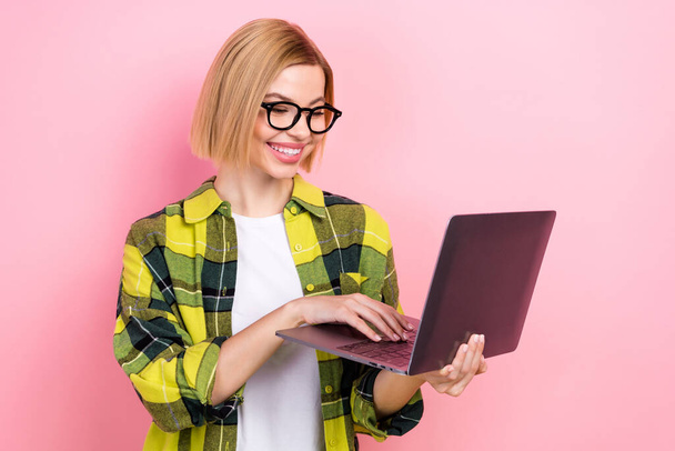 Photo portrait of attractive young woman working hold netbook dressed stylish checkered yellow look isolated on pink color background. - Foto, immagini