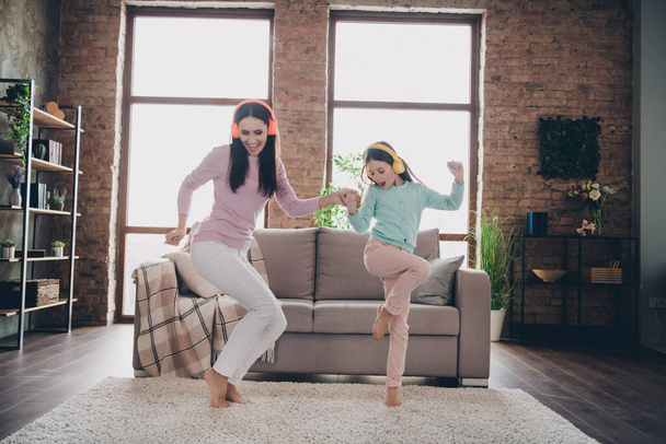 Photo of sweet cheerful mother daughter wear casual outfits listening songs having fun together indoors house room. - Photo, image