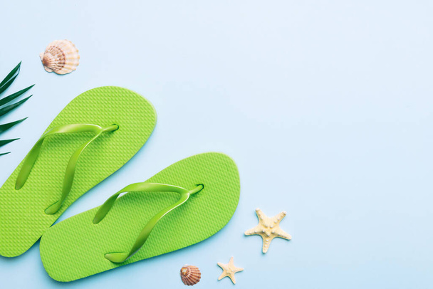 Flat lay composition with flip flops and seashell on colored background. Space for text top view. - 写真・画像