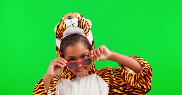 Sluneční brýle, tygří šaty a dětský obličej se zelenou obrazovkou ve studiu pocit hravosti. Komický, vzrušený úsměv a bláznivý portrét dítěte s vtipnou, komedií a vtipem od holčičky se štěstím. - Záběry, video