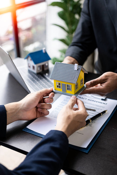 Insurance agent pointing to pen interested in renting a house sign a contract to buy a house Real estate salesman describing a house and making a home purchase contract. Vertical image. - 写真・画像