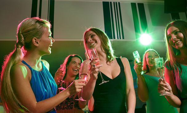 young women with glasses of champagne in club - 写真・画像