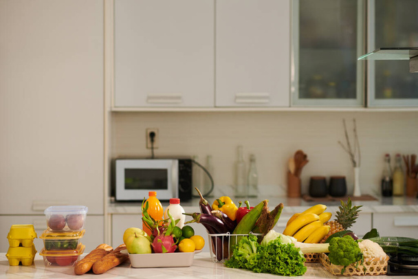 Mostrador de cocina con varios comestibles frescos, frutas y verduras - Foto, imagen