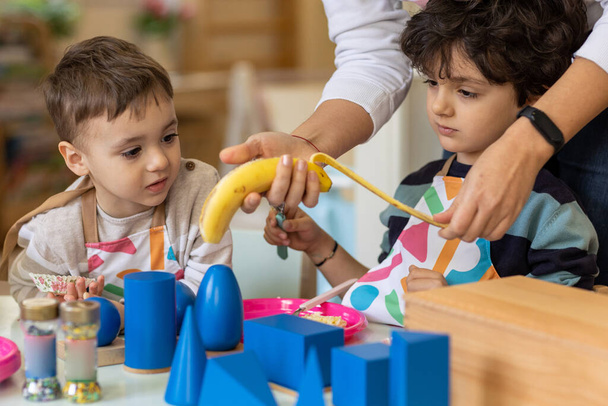 Kids prepering food in the montessori  kindergarten,  banana cokies - Foto, Imagen