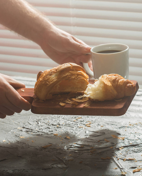 Snídaně s croissantem na prkně a černou kávou. Ranní jídlo a snídaně. - Fotografie, Obrázek