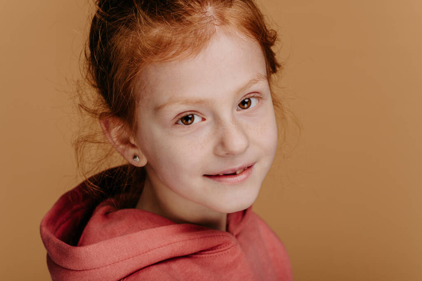 Portrait of little redhead girl in hoodie, studio shoot. - Foto, Imagem